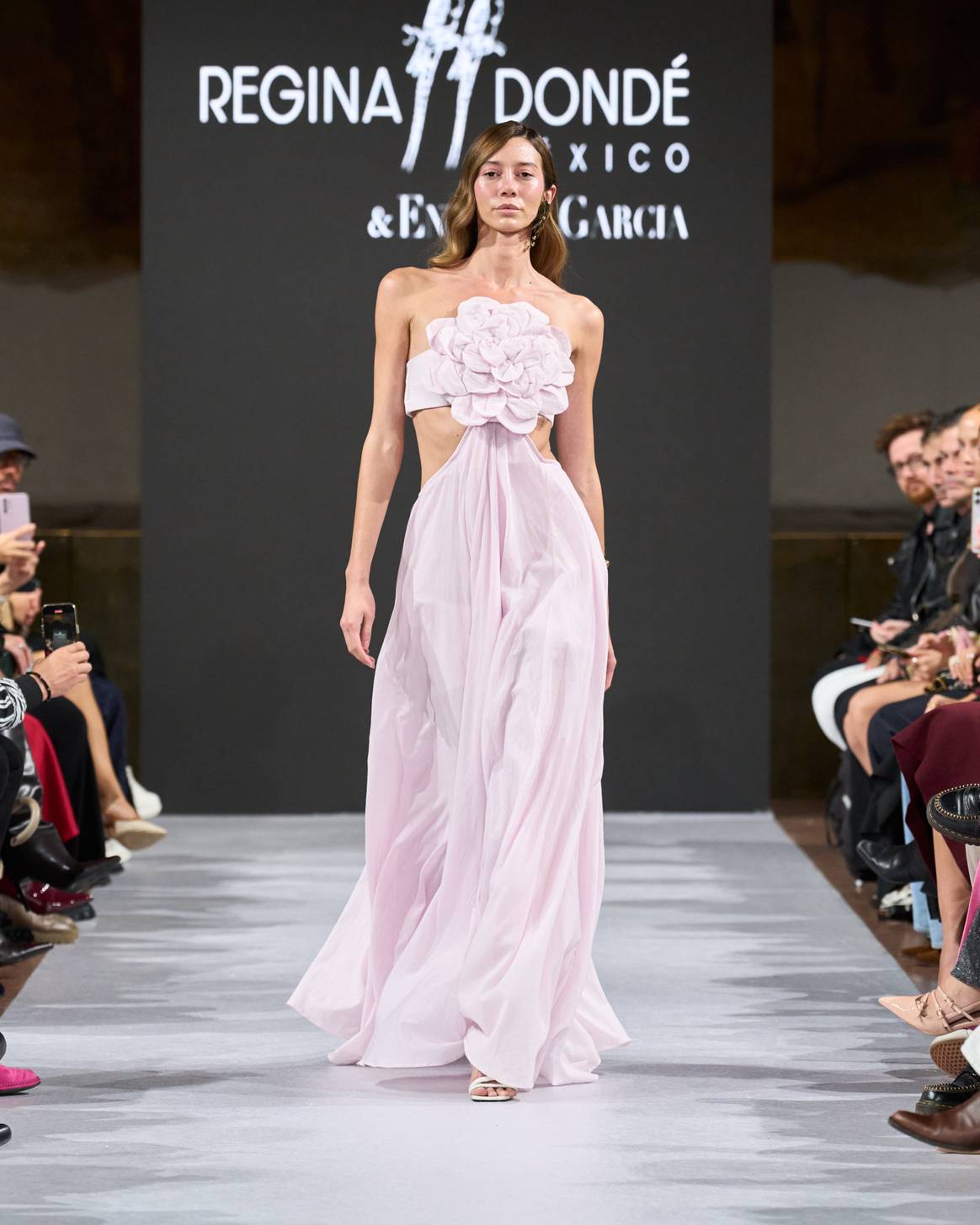 Con un sutil tono rosa y una llamativa flor como protagonista, este vestido sorprendió ya que en la parte posterior luce unas brillantes rayas de color rosa mexicano.