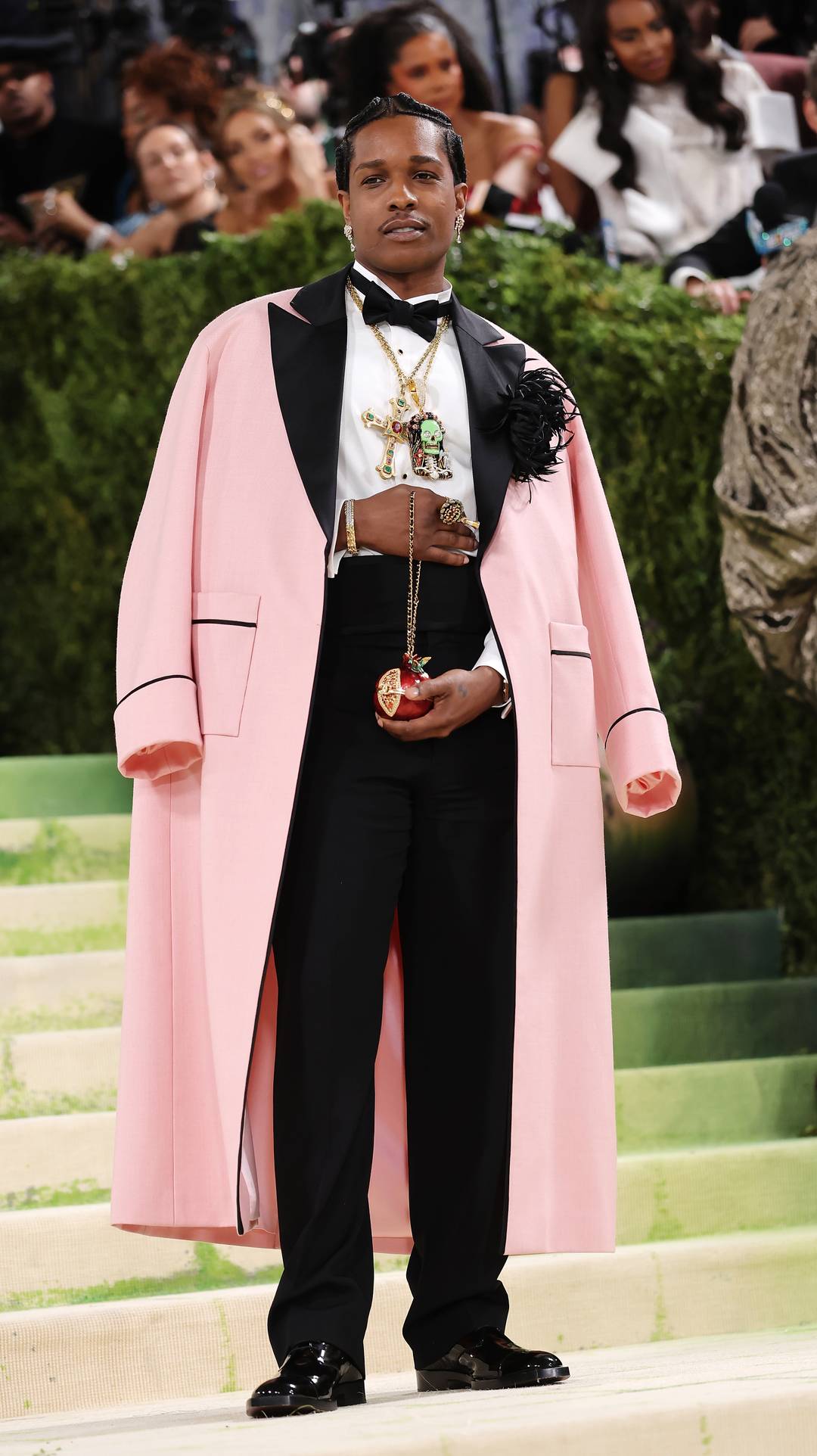 Lors du Gala du Met, en 2026, Asap Rocky, ambassadeur Chanel, portait une robe de chambre Chanel en laine rose, ornée d'un camélia en soie noire et de plumes.