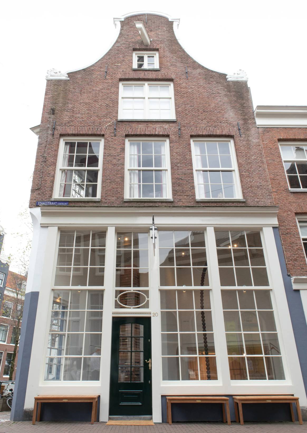 De buitenkant van de winkel, met bankjes waar bezoekers kunnen zitten.