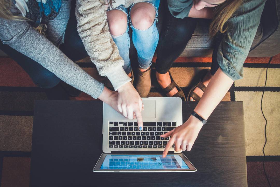 Illustrative image of students working together on a laptop.