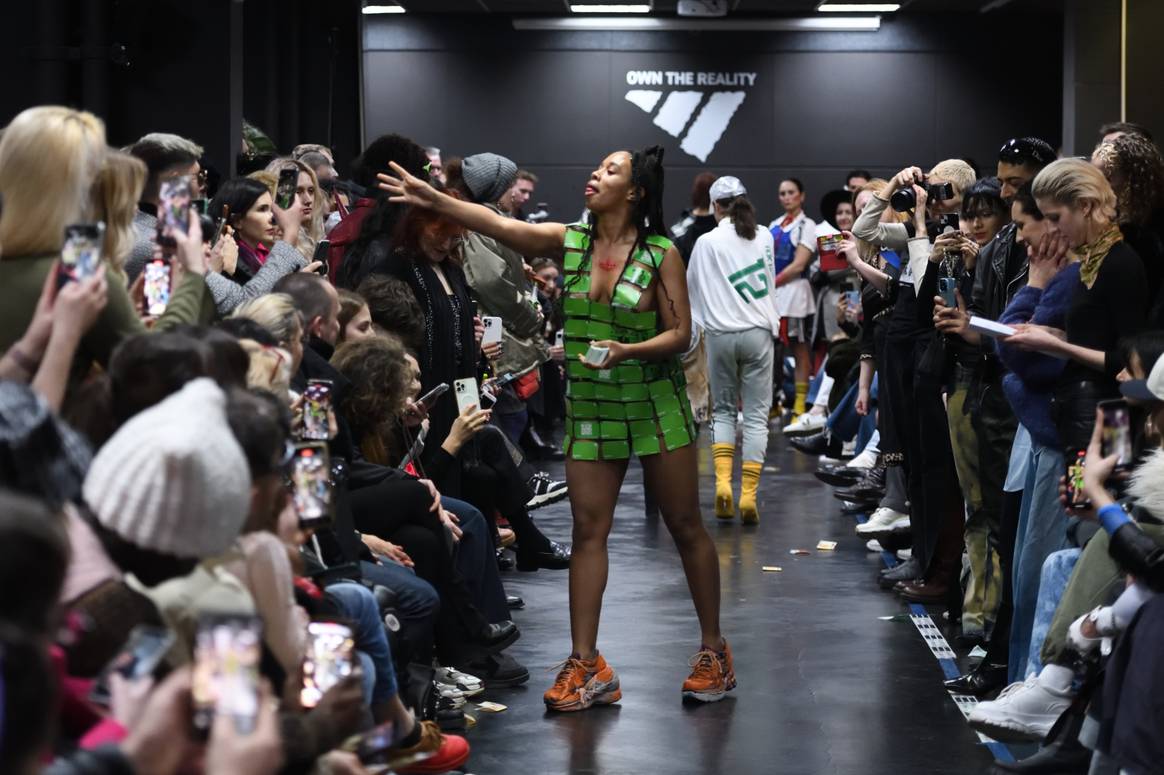 Una modelo con la marca Adidas reparte vales con la inscripción "El regalo perfecto: por fin pagamos a nuestros trabajadores:por dentro". Imagen: Michael Wittig Berlín