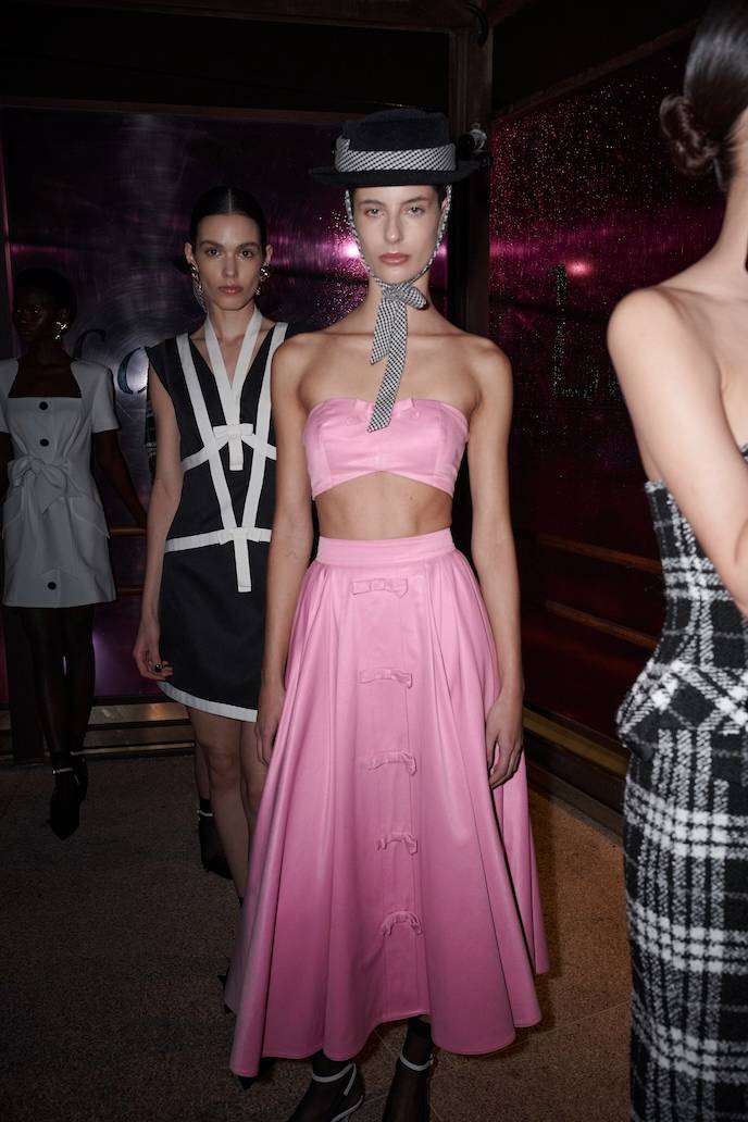 O vestido marinho e branco, assim como a saia e top rosa recriam peças do último desfile do designer