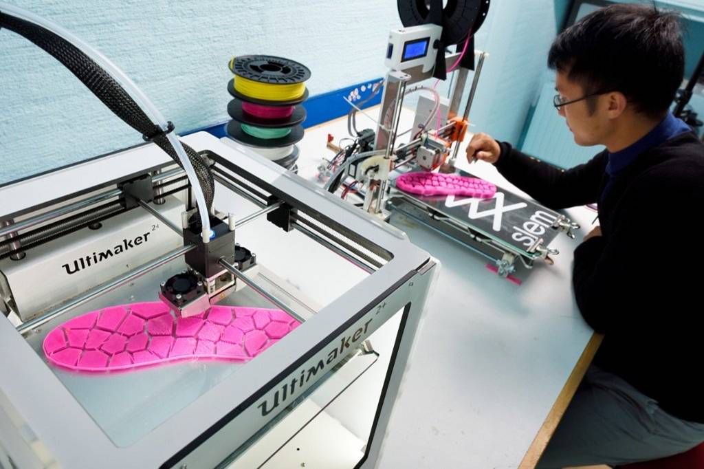 Stock image of shoe soles being 3D printed.