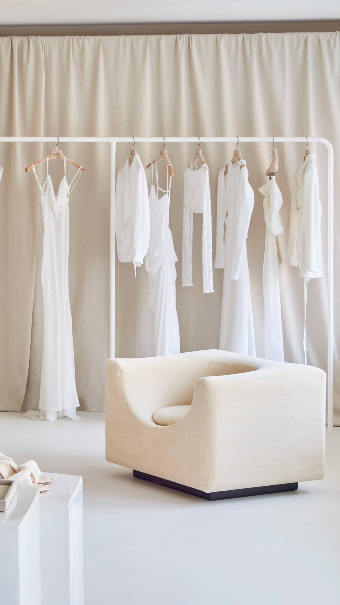 Kleiderauslagen und ein Sitzbereich in der 'La Boutique Montaigne' von Jacquemus. Foto: Adrien Dirand