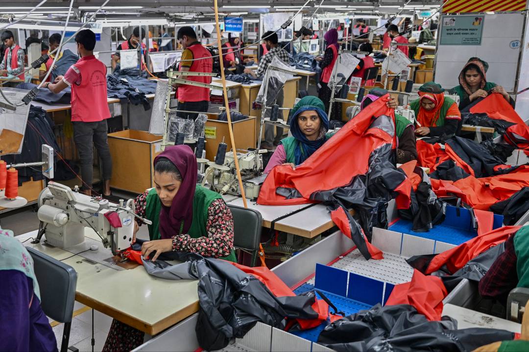 Cette photo prise en décembre 2024 montre des ouvriers du secteur de la confection en train de coudre des vêtements dans une usine textile du groupe Snowtex à Dhamrai, un sous-district de Dhaka, au Bangladesh.