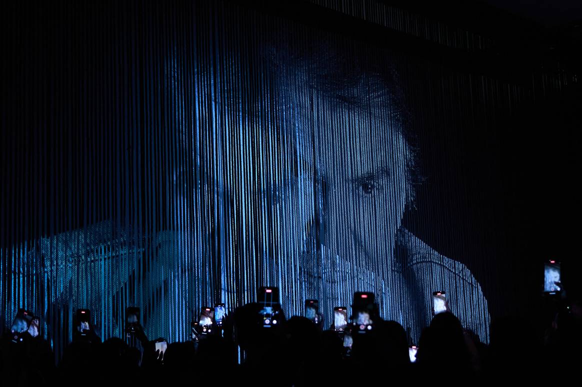 Roberto Cavalli's face is projected onto the backdrop of the runway, SS25.