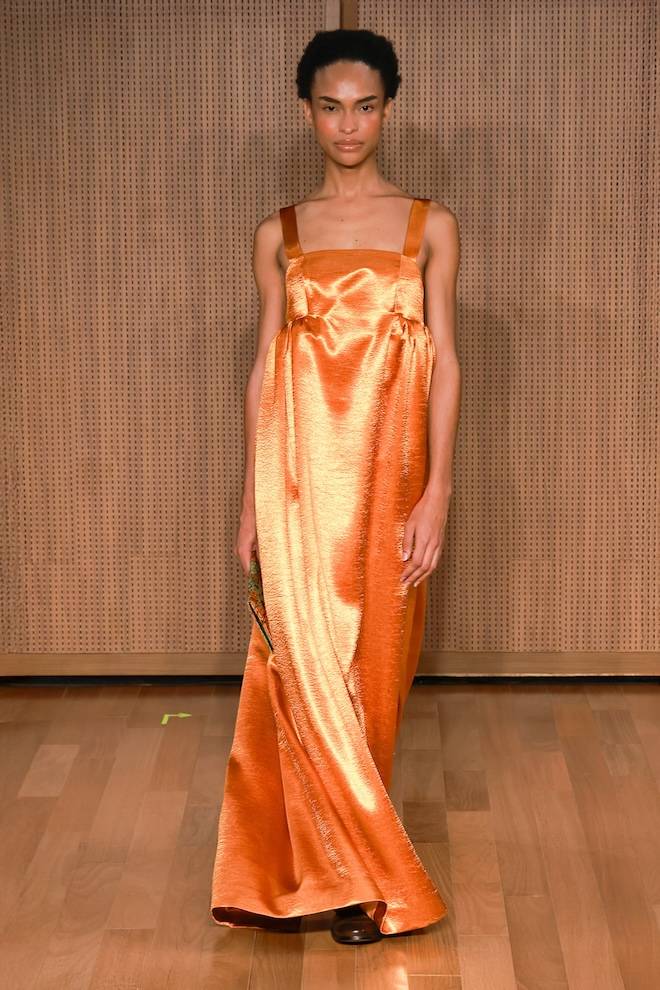 A cor laranja destaca o cetim do vestido À La Garçonne