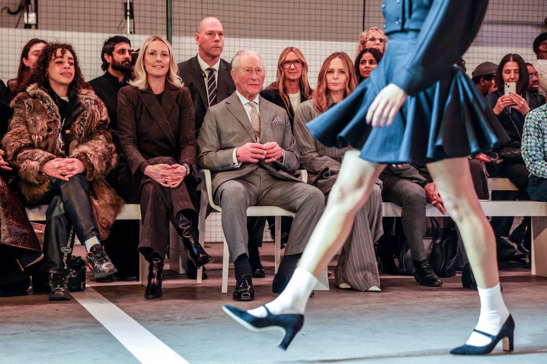 Re Carlo III d'Inghilterra osserva la sfilata di apertura della London Fashion Week 2026, a Londra il 19 febbraio 2026, accanto alla stilista britannica Stella McCartney (a destra).