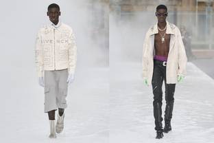 El hombre Givenchy lleva capucha, torso desnudo y botas de lluvia