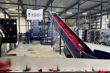 Textiles2Textiles gebruikt machine die automatisch kleding scheidt van knopen en ritsen