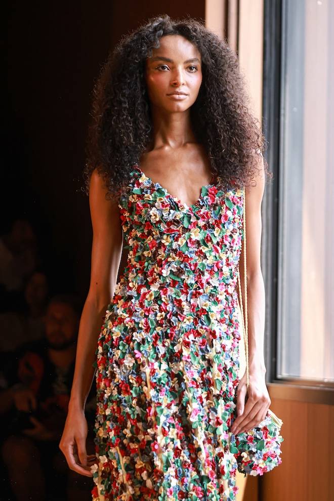 Aplicação minuciosa de flores de pedaços de couro em Patrícia Vieira