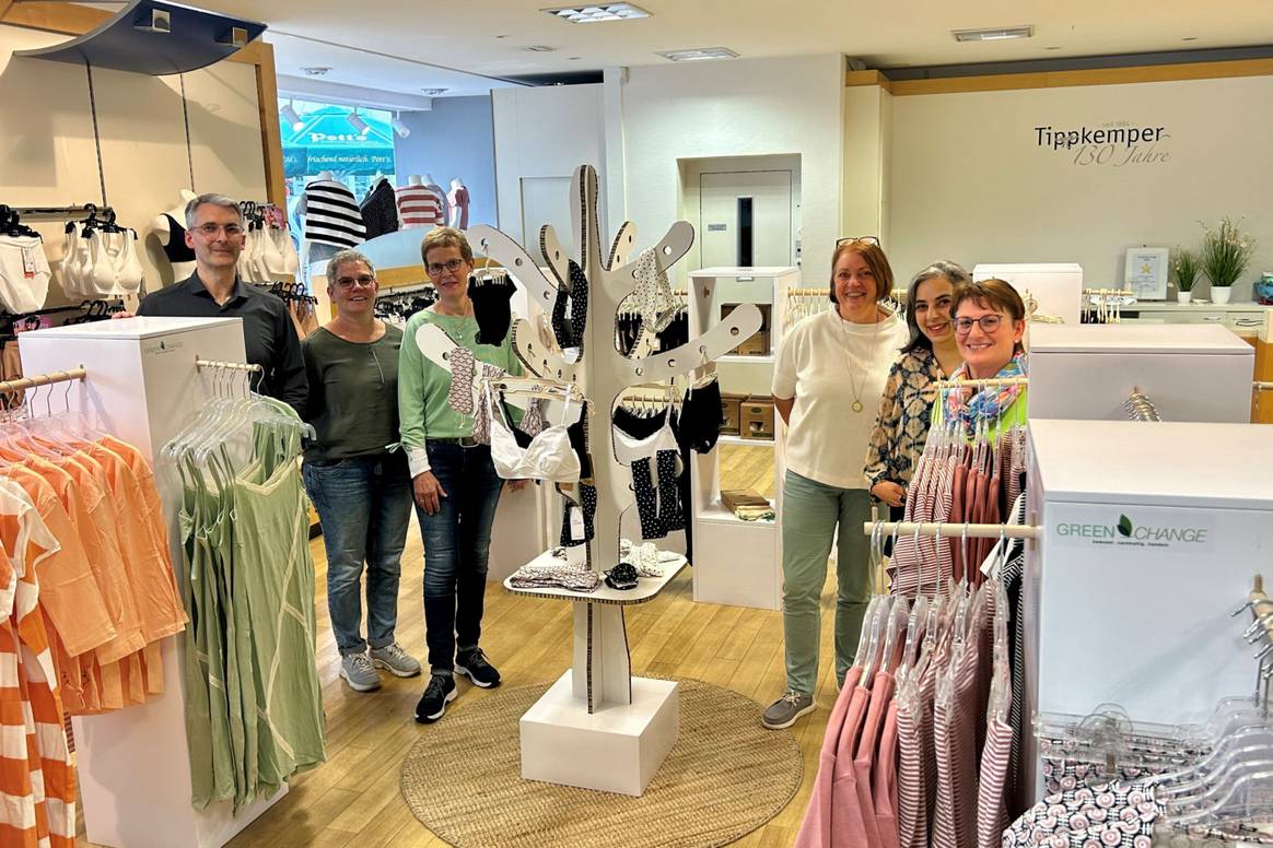 Inhaber Jörg Tippkemper und Team in der Fair Fashion Fläche mit Wäsche.