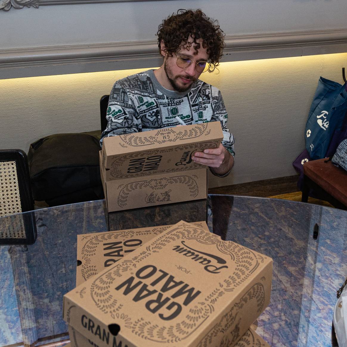 Luisito Comunica firmando algunas cajas de la colaboración.