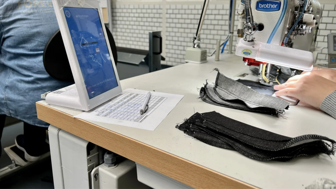 So far, 11 machines at neuralgic points are connected with each other, such as the pocketsetter or bundle sewing machine. This allows the flow of goods to be monitored closely. The current status of an order can be displayed on a tablet at each working station - in other words, how many parts of an order have been produced and where. The aim is to balance the flow of goods, and all machines are expected to be linked up by the end of the year.Credits: C&A FIT ©2022 C. Niehlinger