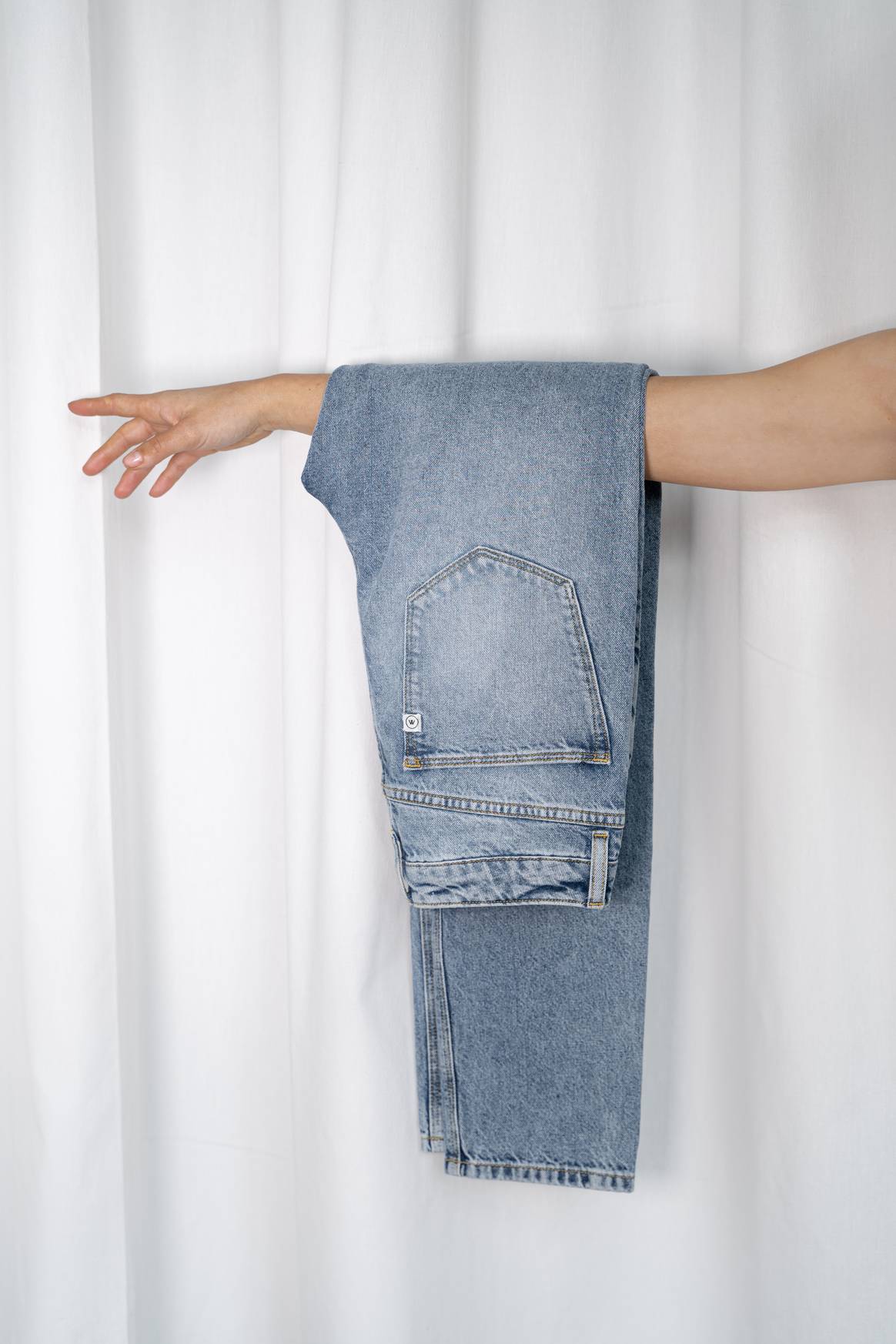Un detalle distintivo del denim es que los hilos azules están en el exterior y los hilos naturales están en el interior. Puedes ver eso en el dobladillo del pantalón que aparece en la foto. Imagen: Kings of Indigo FW22 vía UPR PR NL. Imagen: Vaqueros fabricados íntegramente con fibras recicladas postconsumo, desarrollados por Mud Jeans y la Universidad de Ciencias Aplicadas de Saxion. Crédito: Mud Jeans y Saxion vía Mediatic PR