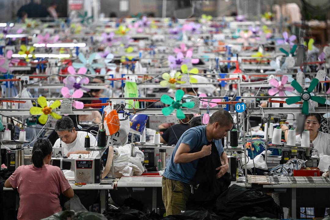 Deze foto, genomen op 11 juni 2024, toont arbeiders die kleding produceren in een textielfabriek die kleding levert aan het fast fashion e-commercebedrijf Shein in Guangzhou, in de zuidelijke Chinese provincie Guangdong.