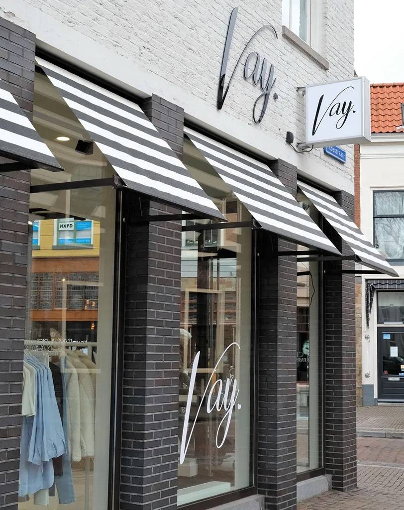 De gevel van modeboetiek Vay, met etalages aan beide zijden die vanaf de straat direct een helder beeld geven van het aanbod.