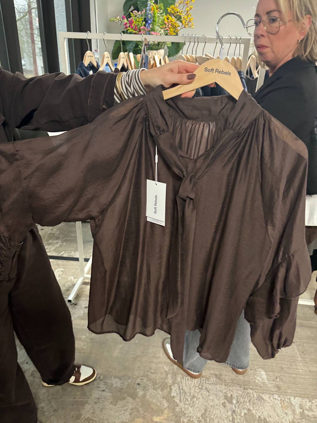 Een vertegenwoordiger van Soft Rebels wijst deze blouse in de kleur Mocha Mousse aan als favoriet