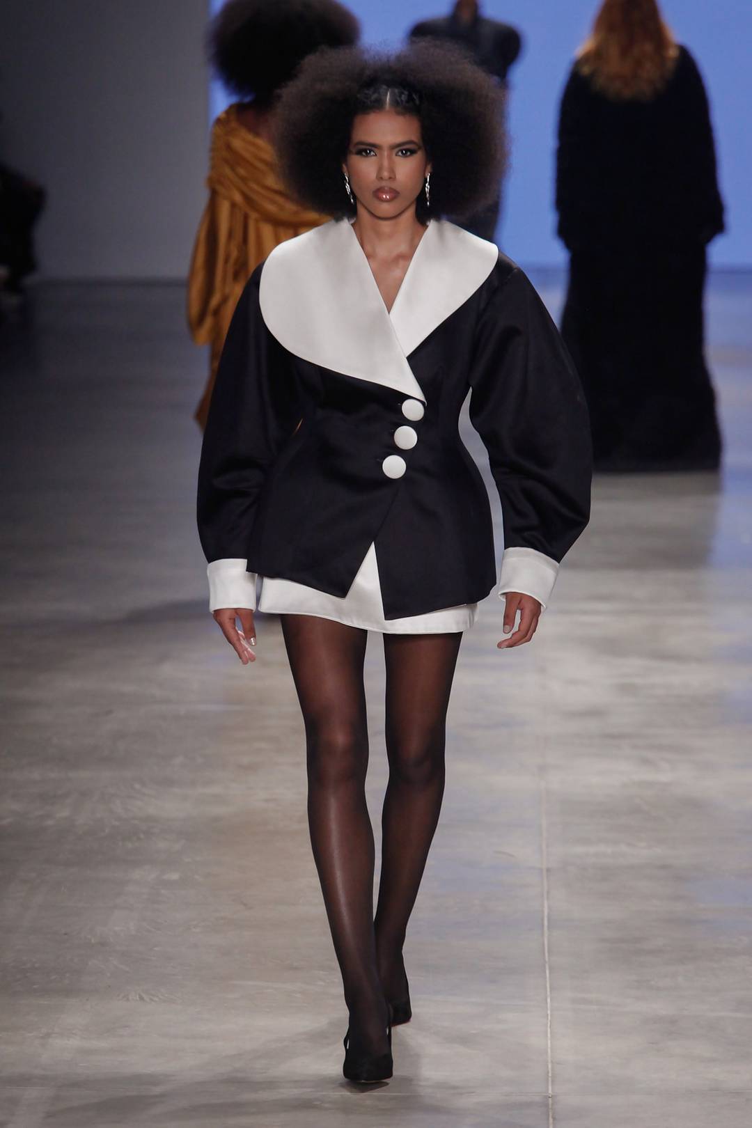 A alfaiataria do tailleur com gola assimétrica privilegiou o corpo feminino em fauve